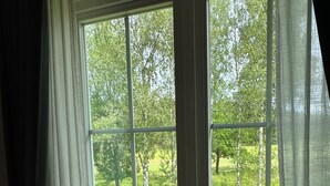 Ein Zimmer mit einer großen Schiebetür und Zugang zu einem grünen Außenbereich.