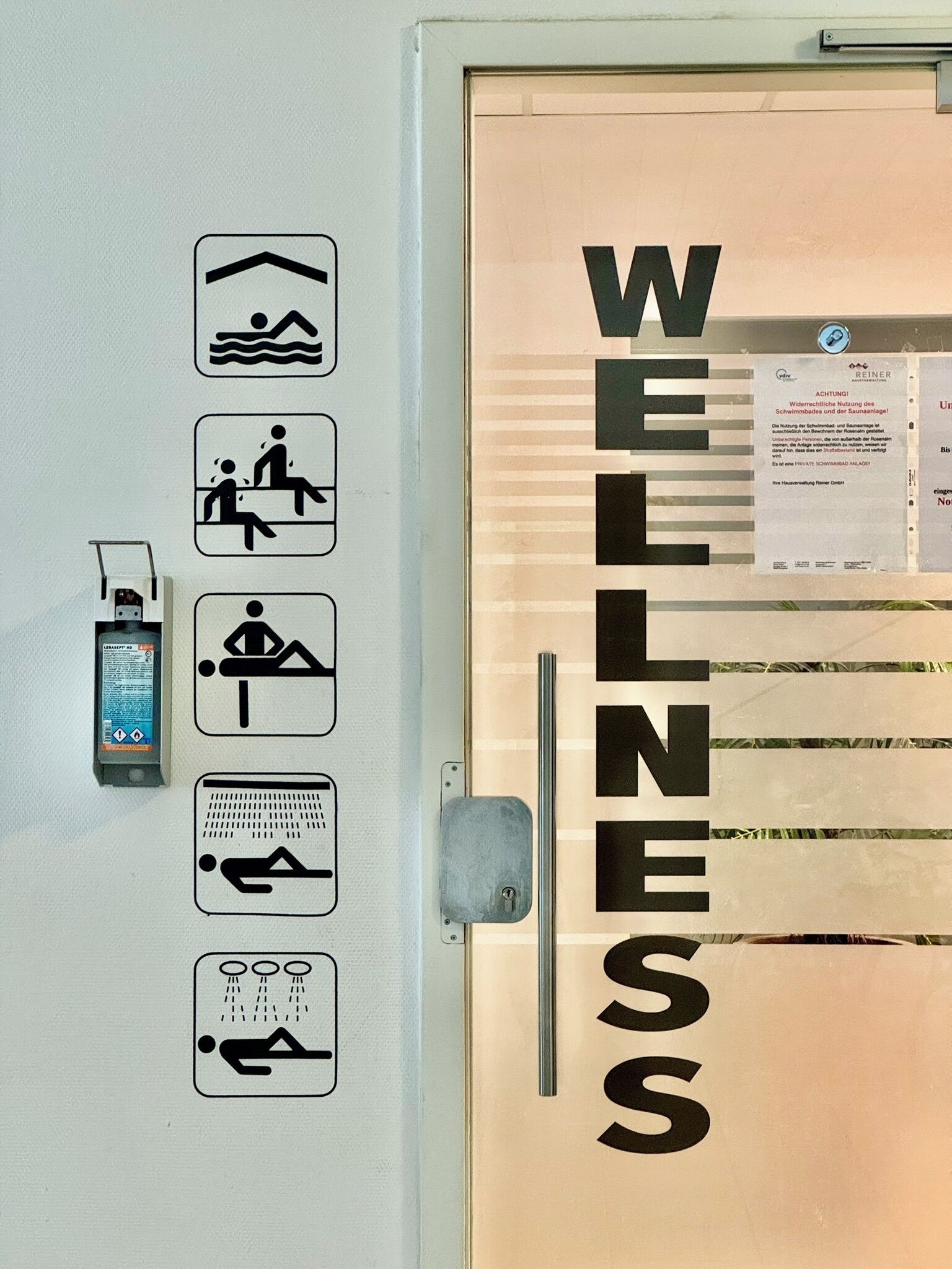 Une enseigne indiquant un centre de bien-être, avec des icônes représentant une piscine, un sauna, des massages et une douche.