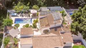 A residential property with a swimming pool, solar panels, and a tiled roof. - Villa Tranquila (Denia)