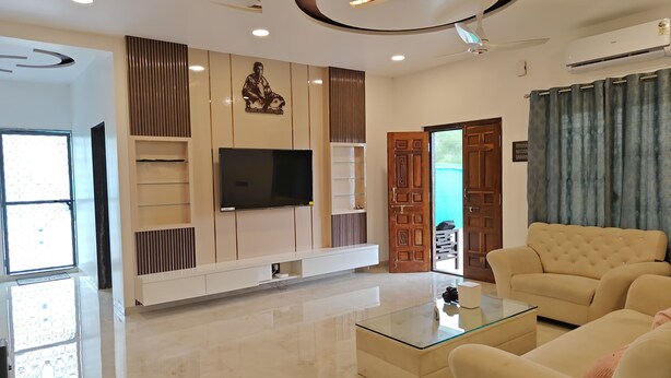 A modern living room with a flat-screen TV, a glass coffee table, and a beige sofa. - Pawna Ns4 villa (Mawal)