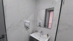 A bathroom with a white sink, a mirror, and a hand dryer. - Seashell (Oualidia)