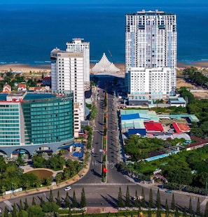 A high-rise hotel with a view of the beach and ocean.
