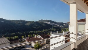 A balcony with a view of a hillside town. - Outeiro 7 (Penacova)