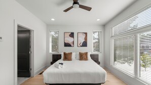 A bedroom with a large bed, a ceiling fan, and two windows with blinds. - Modern Luxury in West Midtown 4BR with Rooftop (Atlanta)