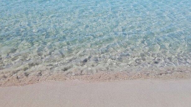 A clear view of a sandy beach with shallow water. - House Relax sea view Sardinia (Funtana Meiga)