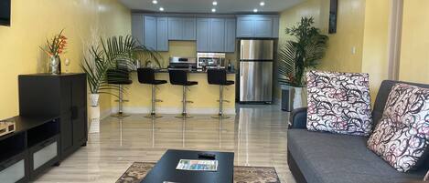 A modern living room with a sofa, a coffee table, and a TV.