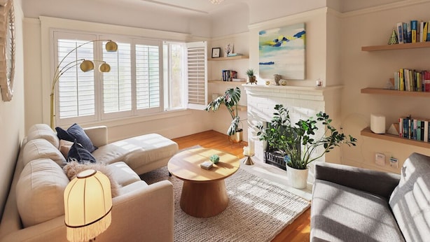 A cozy living room with a sofa, a coffee table, and a fireplace. There are bookshelves and a painting on the wall. - Spacious 2BR Potrero Hill Home  Minutes to Moscone & Caltrain for Super Bowl (San Francisco)