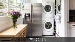 A compact kitchen with a refrigerator, a washing machine, and a water dispenser. - Spacious 2BR Potrero Hill Home  Minutes to Moscone & Caltrain for Super Bowl (San Francisco)