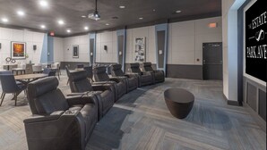 A conference room with a long row of leather chairs, a round table, and a projector screen. - Landing | Beautiful 1BD, Pool, Gym (Orlando)