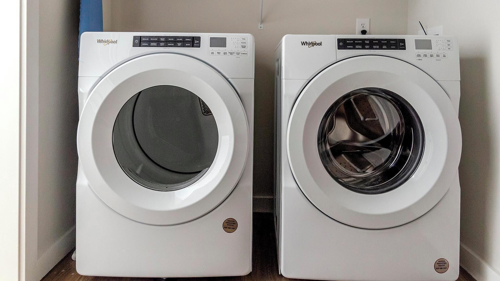 Deux lave-linge Whirlpool à chargement frontal, de couleur blanche, placés côte à côte.
