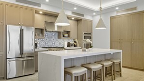 Una cocina moderna con una isla central, electrodomésticos de acero inoxidable y armarios de madera.
