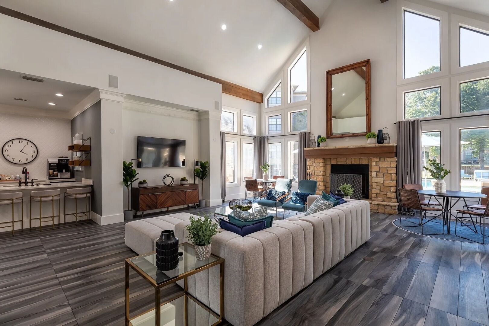 A spacious living area with a large sectional sofa, a fireplace, and a dining area with a table and chairs.