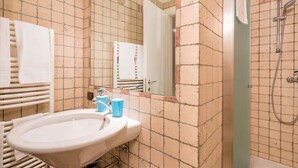 A bathroom with a sink, mirror, and shower. - Charm and comfort at a stone's throw from the Arena (Verona)