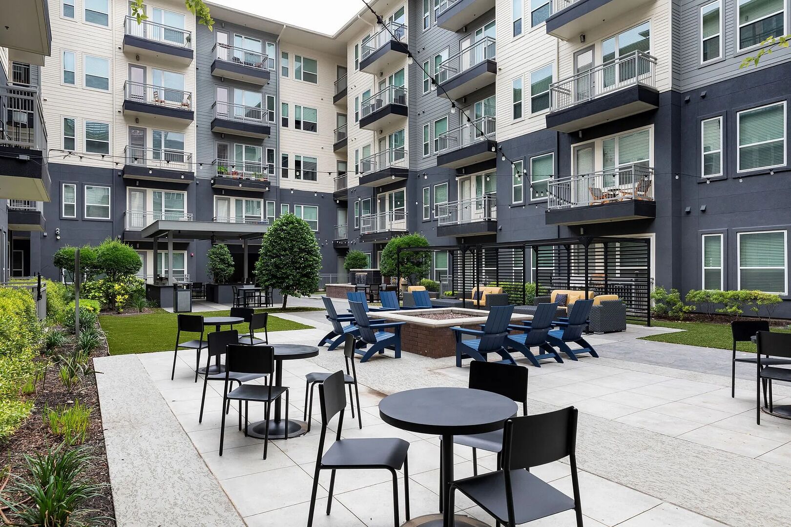 A courtyard with outdoor seating, a fire pit, and a small tree.