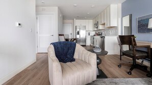 Una sala de estar moderna con un sofá color beige, una mesa de centro y una manta azul.