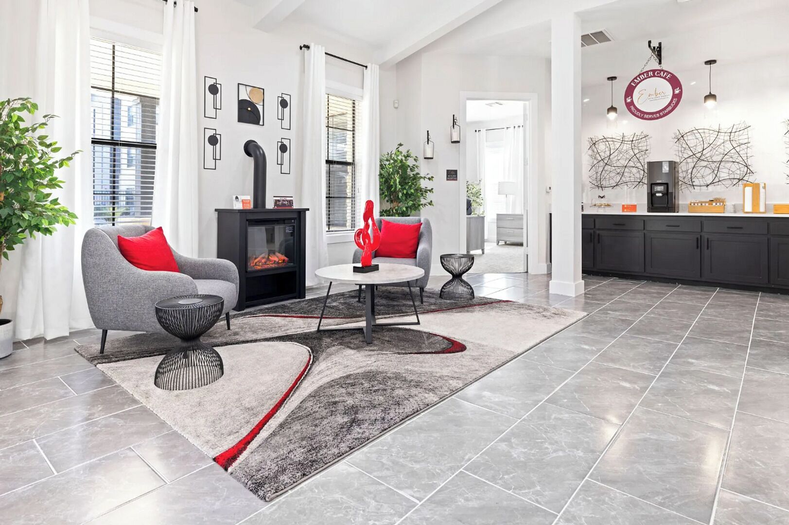 A modern living room with a fireplace, grey sofa, red cushions, and a coffee table.