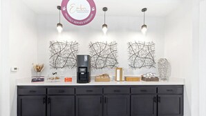 Una cocina moderna con cafetera, decoración en la pared y un cartel que indica la presencia de Starbucks.
