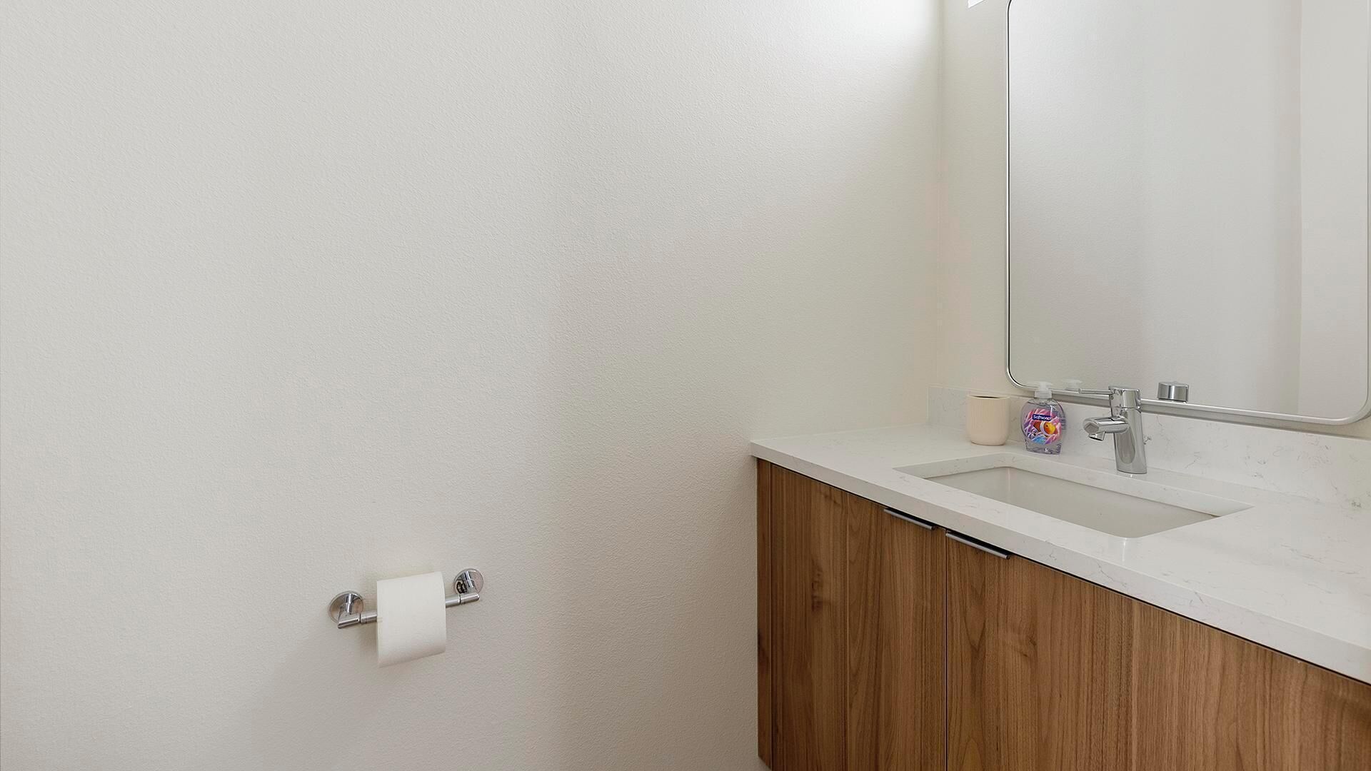 Ein Badezimmer mit Waschbecken, Holzschrank und Spiegel.