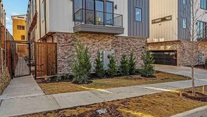 A modern multi-story building with a flat roof, large windows, and a stone facade. - Landing | Incredible 2BD in Downtown Dallas (Dallas)