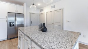 A kitchen with granite countertops, stainless steel appliances, and pendant lighting. - Landing | Spectacular 1BD, Gym, Clubhouse (The Villages)