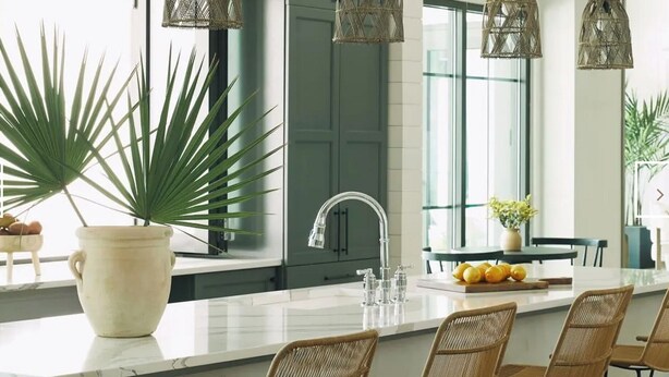 Cocina moderna con una isla central, muebles oscuros y un ventanal amplio.