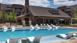A swimming pool with lounge chairs and a covered patio area. - Landing | Incredible 1BD, Clubhouse, Pool (Madison)