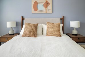 A neatly made bed with two pillows and two bedside tables with lamps. - Landing | Spectacular 2BD, Pool, Gym (Bellview)