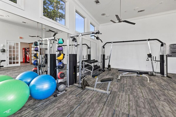 A gym with exercise equipment, large exercise balls, and a ceiling fan. - Landing | Stunning 2BD, Gym (League City)