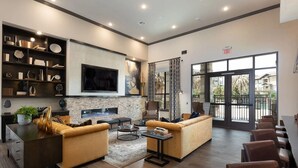Una sala de estar moderna con chimenea, asientos cómodos y un ventanal con vistas al exterior.