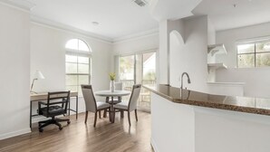 A spacious kitchen with a dining area, large windows, and a modern design. - Landing | Modern 1BD, Yoga Studio (Jacksonville)