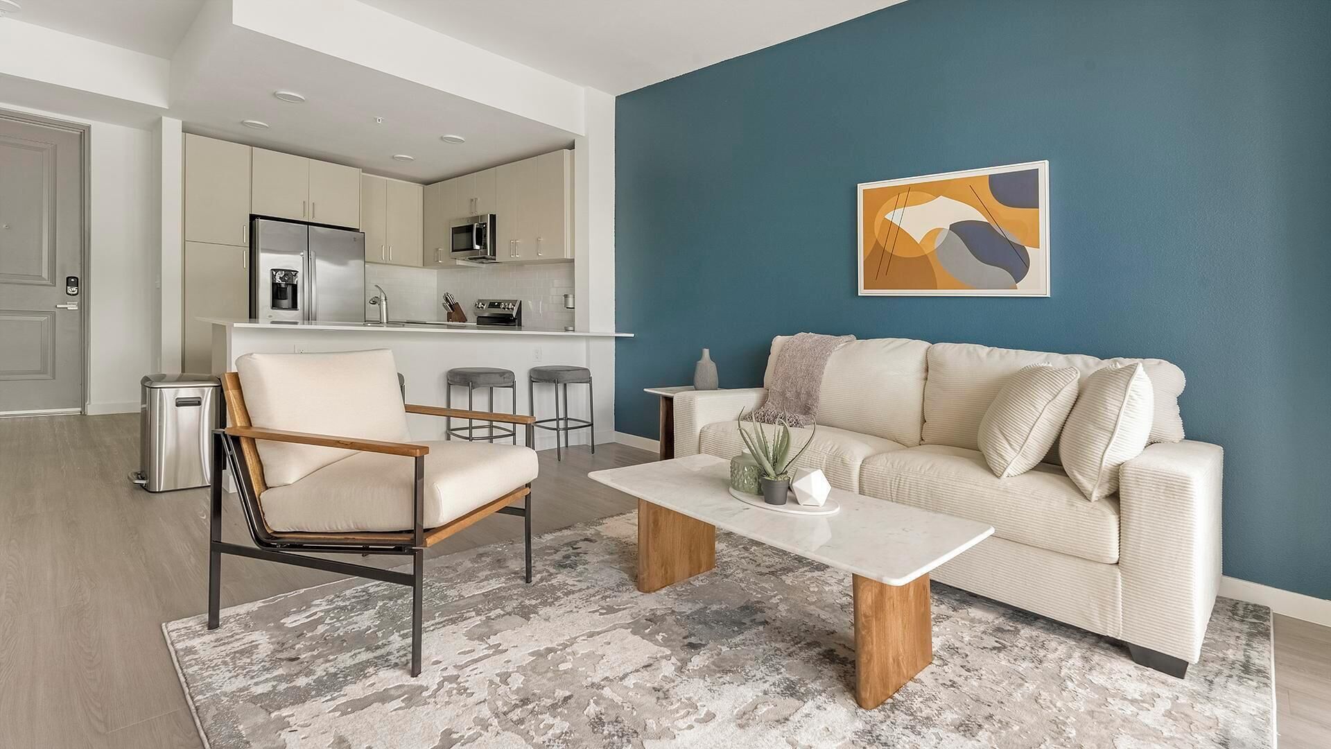 A modern living room with a beige sofa, a wooden coffee table, and a minimalist design.