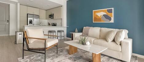 A modern living room with a beige sofa, a wooden coffee table, and a minimalist design.