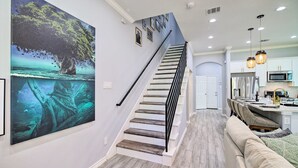 Un escalier menant à une cuisine avec un coin repas.
