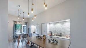 A modern kitchen with a large island, stainless steel appliances, and pendant lighting.