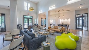 A spacious living area with a sofa set, armchairs, a coffee table, and a bright green accent chair.
