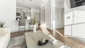 Una sala de estar moderna con un sofá, una mesa de centro y un control remoto.