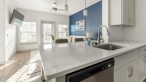 Una cocina moderna con lavavajillas, un lavabo y un ventilador de techo.
