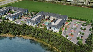 An aerial view of a hotel complex with multiple buildings, a swimming pool, and a parking lot. - Landing | Modern 2BD, Gym (Fort Myers)