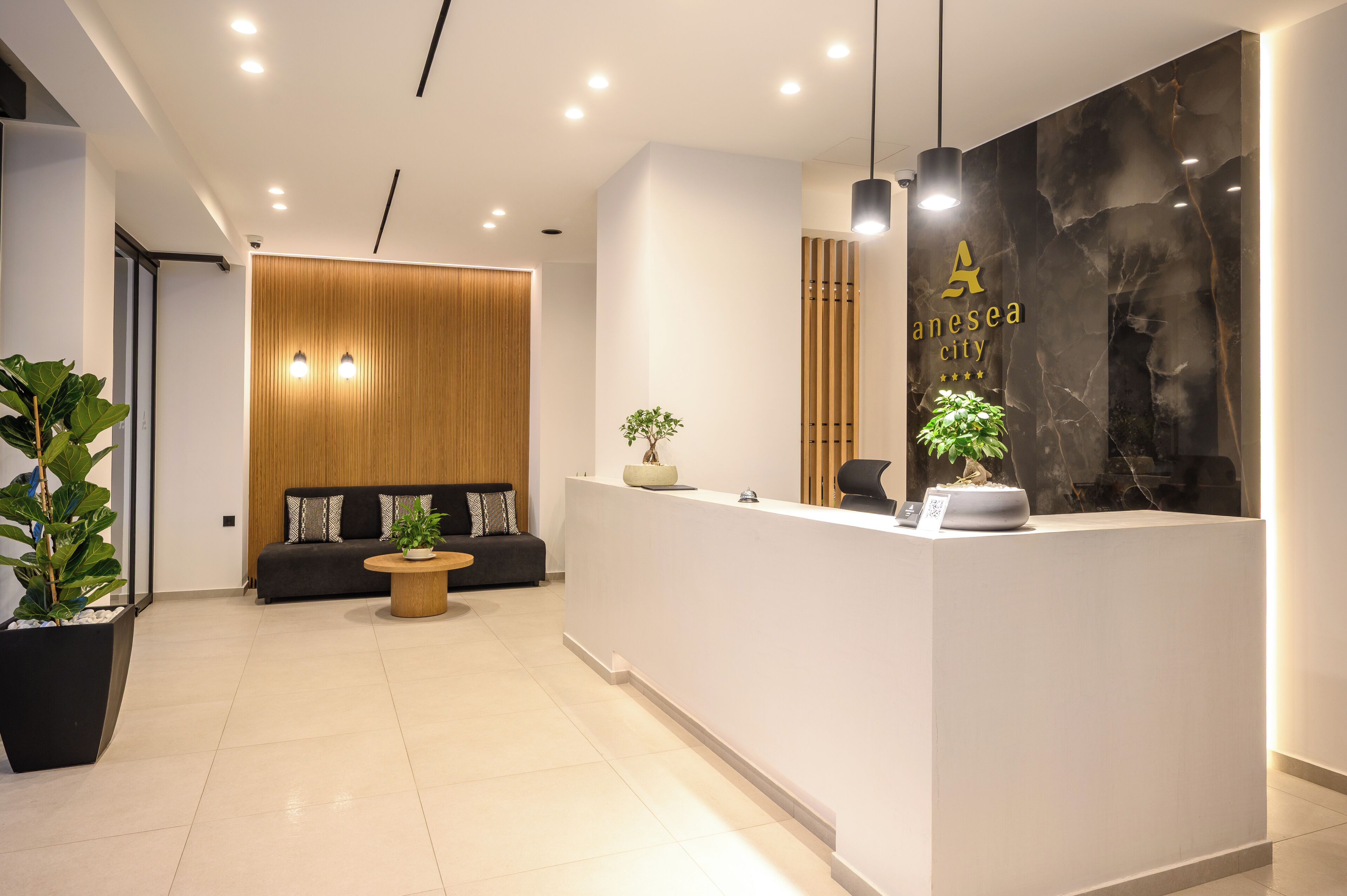 A modern reception area with a reception desk, seating area, and a large wall with a logo.