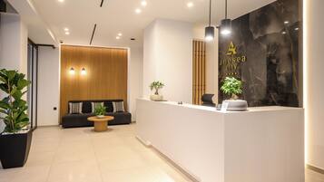 A modern reception area with a reception desk, seating area, and a large wall with a logo.