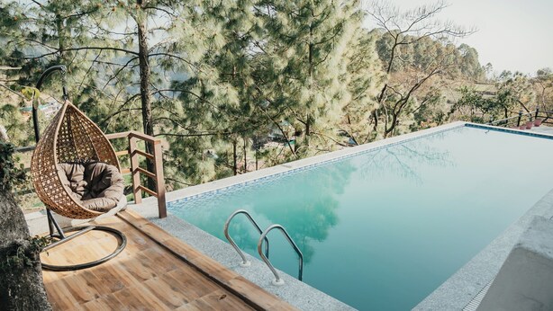 Ein Pool mit Holzterrasse und einer Hängematte.