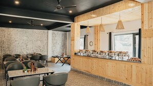 Ein Restaurant mit Holzvertäfelung, mehreren Tischen, Stühlen und einer Theke mit Küchenausstattung.