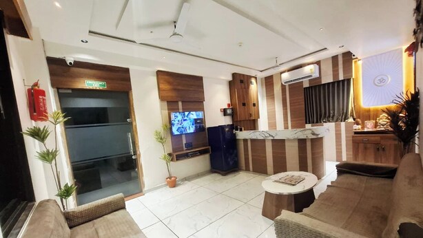 Un moderno vestíbulo de hotel con una zona de estar, un mostrador de recepción y una televisión.