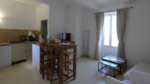 Un espacio habitable compacto con cocina, comedor y una pequeña zona de estar.
