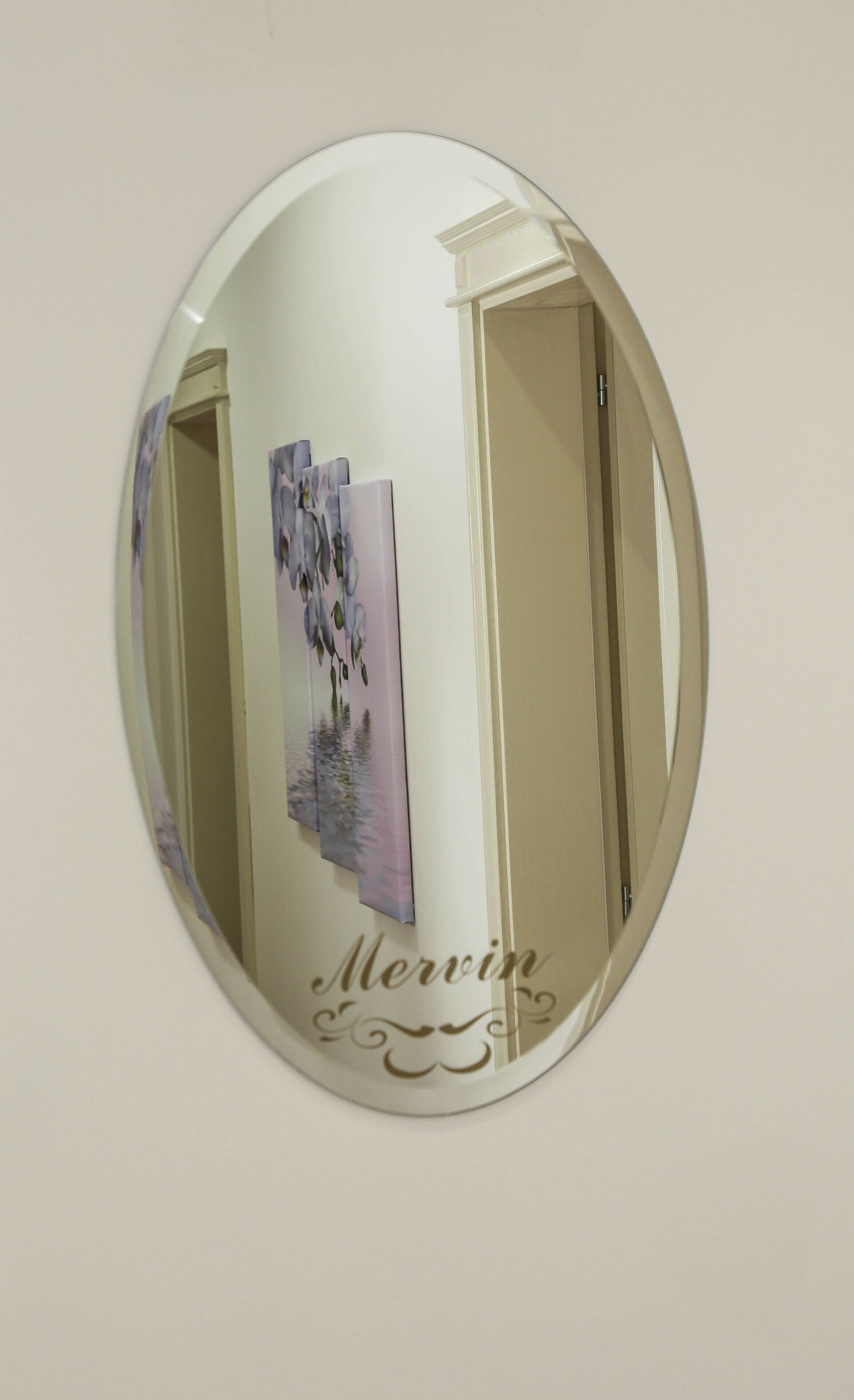 A round mirror with a floral artwork and the name "Mervin" on it.