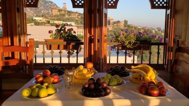 Un tavolo con frutta e vista su un paesaggio montuoso.
