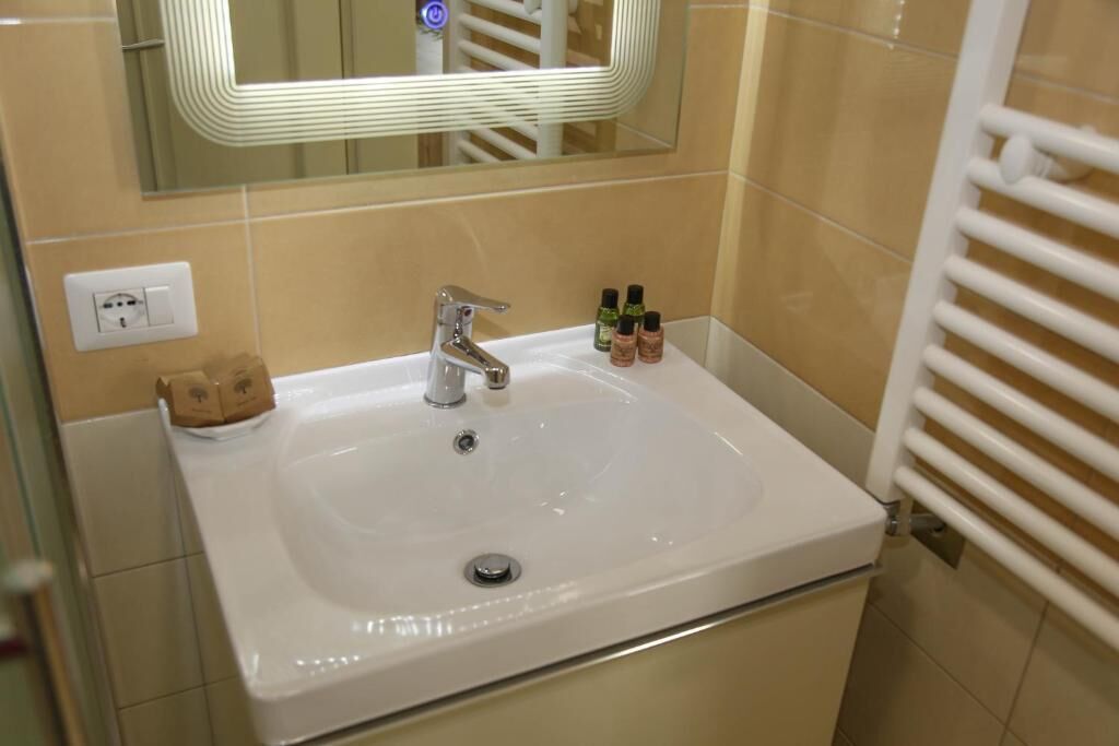 A bathroom with a white sink, a mirror, and a towel rack.