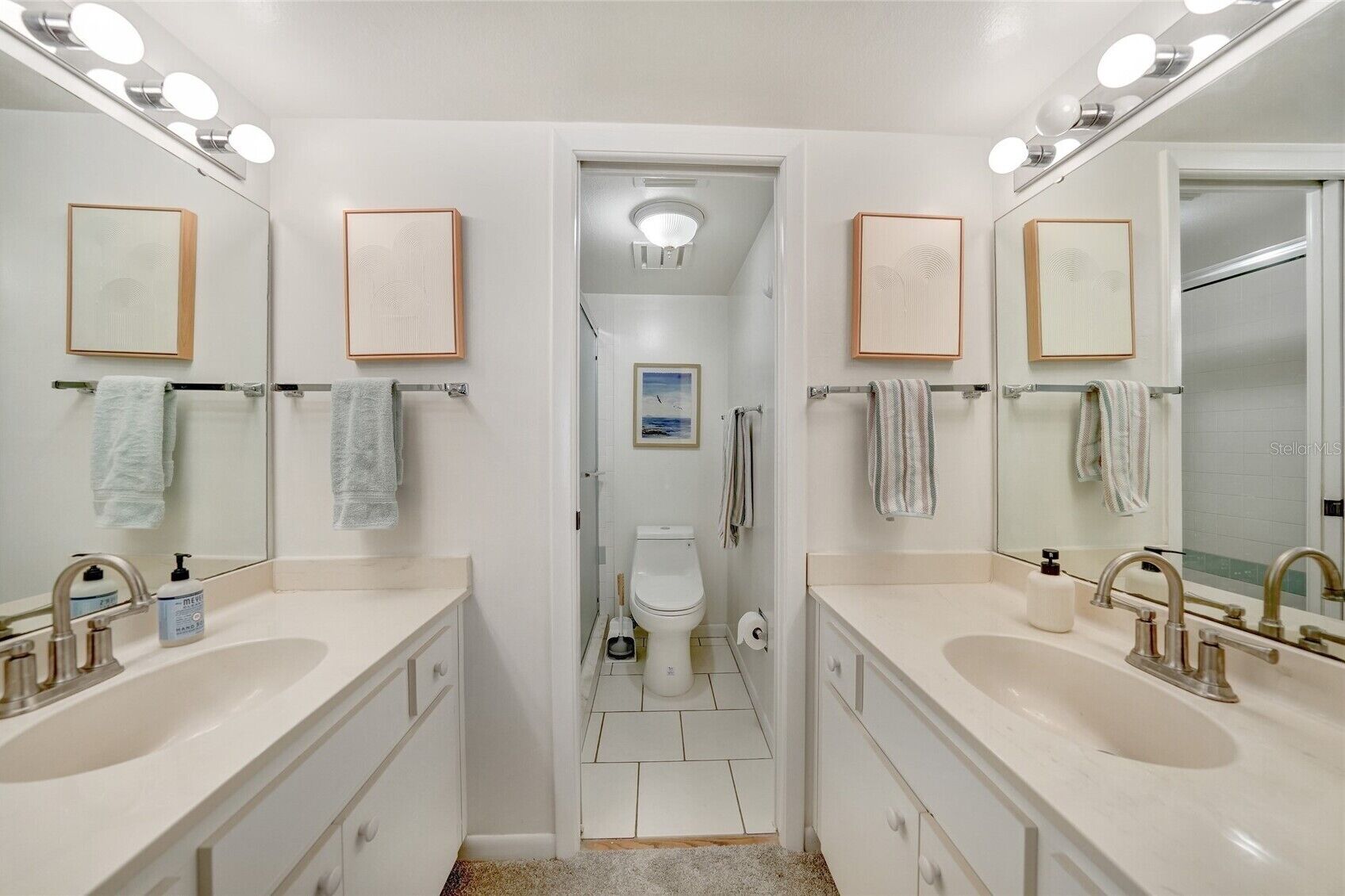 Une salle de bain moderne avec deux lavabos, des toilettes et une douche.