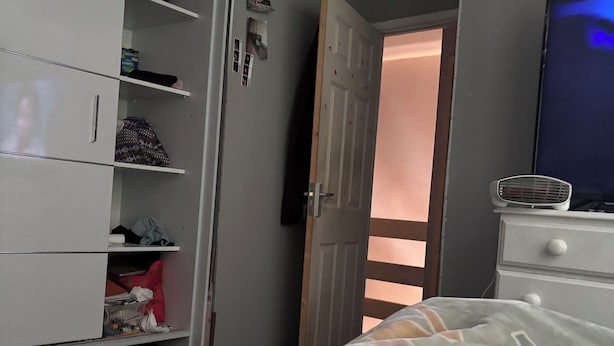 A bedroom with a bed, a wardrobe, a television, and a door leading to another room. - Cosy room for Female Couple and Families (Manchester)