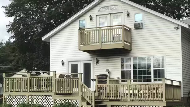 Een huis met twee verdiepingen, een balkon, een veranda en een garage.